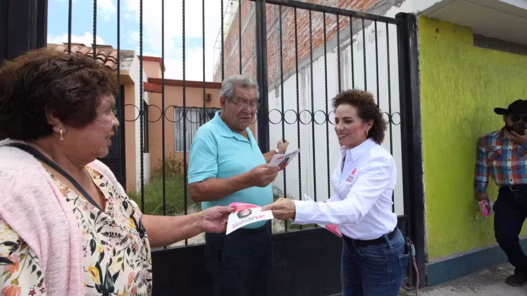adriana-meza-revisa-folletos-con-dos-hombres-durante-su-informe-legislativo-en-san-juan-del-rio