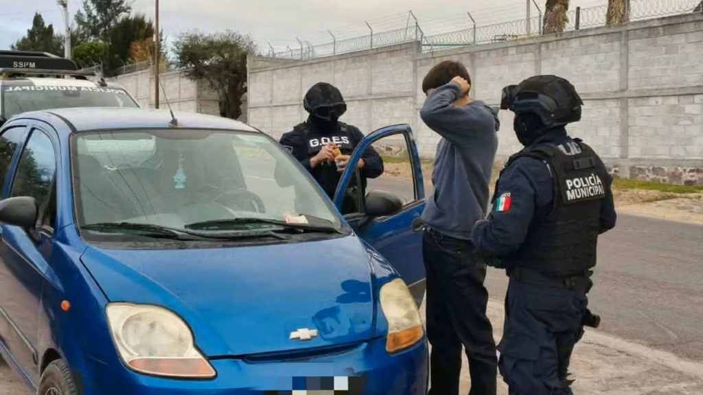 elementos-de-la-policia-municipal-y-del-grupo-g-o-e-s-realizan-una-revision-a-un-hombre-junto-a-un-automovil-azul-durante-el-op
