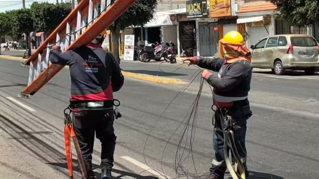 trabajadores-retiran-cableado-obsoleto-en-avenida-pedregoso-de-san-juan-del-rio-uno-carga-una-escalera-y-otro-jala-cables